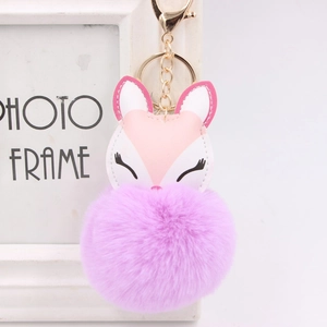 Detail of sweet fox plush keychain with purple faux fur ball and gold lobster clasp