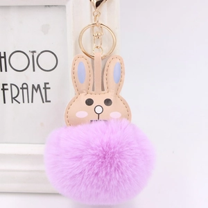 Detail of cute brown rabbit keychain with a fluffy purple faux fur pompom and gold clasp
