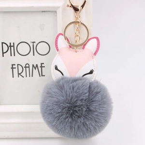 Detailed macro of fluffy grey faux fur ball keychain with pink leather fox ornament