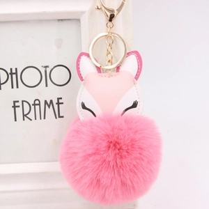 Detail of pink faux fur fox keychain hanging on a white photo frame with gold ring