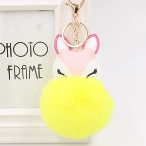 Detail of yellow plush fox keychain with pink ears and golden alloy hardware