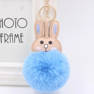 Detail of cute blue rabbit plush keychain with soft faux fur pompom and golden ring