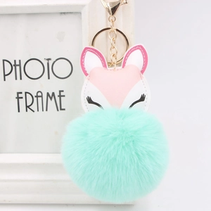 Close-up of mint green faux fur fox keychain with golden metal clasp and faux leather face