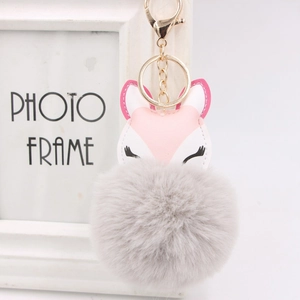 Detail of fox PU leather charm with large fluffy grey faux fur pom pom and gold clasp
