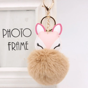 Detail of pink fox leather charm with fluffy brown faux fur pom pom and gold lobster clasp