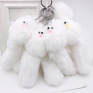 Fluffy white plush animal keychain with pink blush and metal ring on white background
