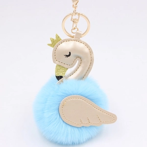 Macro detail of swan plush keychain with faux leather wings and golden crown decoration