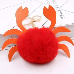 Vue détaillée du porte-clés crabe en fausse fourrure rouge avec pinces en cuir orange