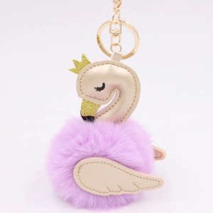 Macro detail of purple plush swan keychain with golden faux leather crown and wing accents