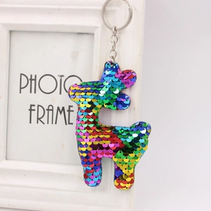Close-up of rainbow sequin alpaca keychain with silver metal ring on white photo frame