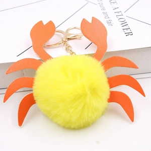 Détail du porte-clés crabe en peluche jaune avec pattes en similicuir orange et fermoir