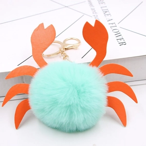 Détail du porte-clés crabe en fausse fourrure vert menthe avec pinces en cuir synthétique orange