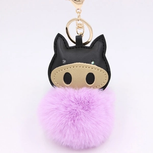 Detail of creative pig keychain with purple faux fur pompom and black leather charm
