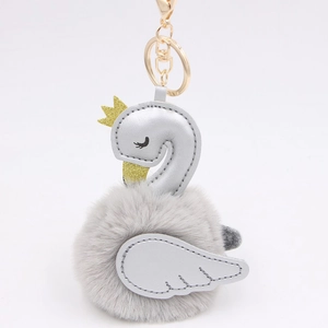 Detail of grey fur swan keychain featuring silver PU wings and golden crown decoration