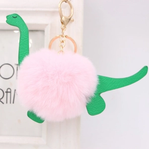 Detail of pink faux fur dinosaur keychain with green leather accents and golden clasp
