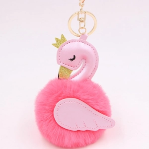 Detailed macro view of the flamingo plush ball keychain with a gold crown and faux leather