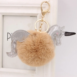 Détail des ailes à paillettes argentées sur le porte-clés licorne en peluche marron