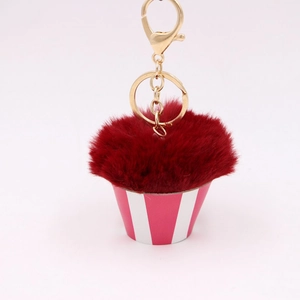 Detail of creative cupcake plush keychain with fluffy dark red ball and pink base
