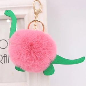 Detail of plush dinosaur keychain with pink fur pompom and green faux leather accents