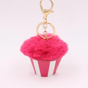 Close-up of pink cupcake pom-pom keychain with golden metal ring and lobster clasp detail