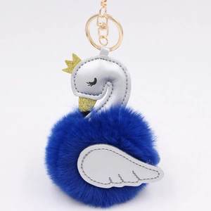 Detail of blue plush swan keychain with silver PU leather and golden glitter crown