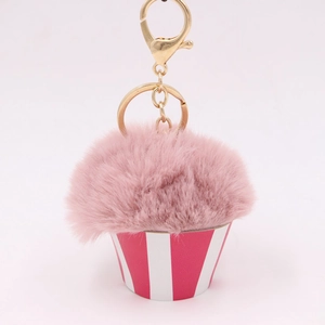 Detailed view of pink pompom cupcake plush keychain with striped base and gold clasp