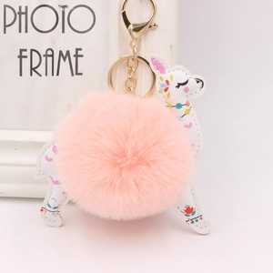 Detail of white deer plush keychain with pink pompom and gold lobster clasp