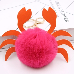 Détail macro d'un porte-clés crabe en fausse fourrure rose vif avec pinces en similicuir