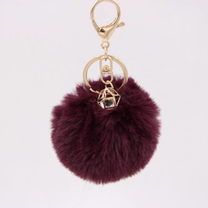 Detail of burgundy faux rabbit fur keychain with gold lobster clasp and diamond pendant