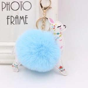 Detail of blue plush fur ball and deer leather keychain with bohemian floral patterns