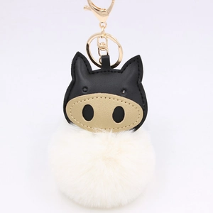 Detail of creative pig plush keychain featuring black faux leather and soft white fur ball