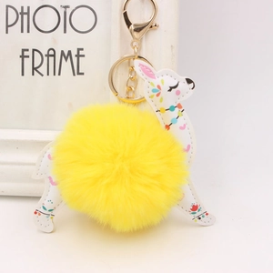 Detail of llama keychain with white faux leather, floral prints and yellow pompom