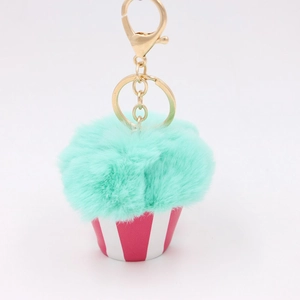 Close-up of mint green faux fur pom pom cupcake keychain with pink striped base