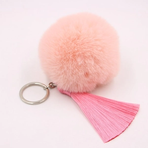 Close-up of fluffy pink faux fur pompom keychain with long matching tassels and silver ring