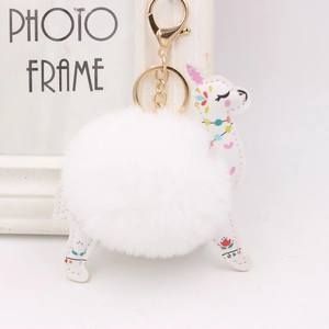 Detail of white plush alpaca keychain with floral faux leather and gold lobster clasp