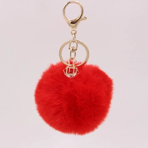 Detailed view of red faux rabbit fur keychain with gold lobster clasp and crystal charm