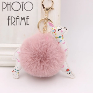 Detail of alpaca plush keychain with pink faux fur ball and gold metal ring for bags