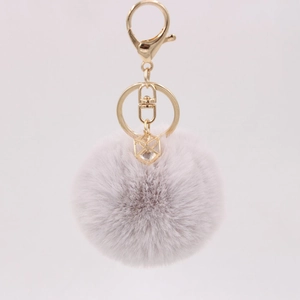 Detailed close-up of light purple faux rabbit fur pom pom keychain with gold rhinestone charm