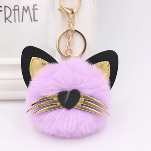 Detailed close-up of a purple plush cat head keychain with gold whiskers and heart nose
