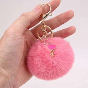 Pink flamingo plush faux fur keychain with gold ring, handheld for size scale