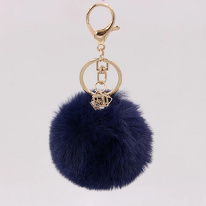 Detail of navy faux rabbit fur keychain with gold lobster clasp and crystal cube pendant