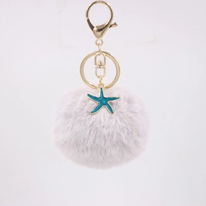 Detailed macro view of the fluffy lavender pompom and blue starfish gold keychain charm