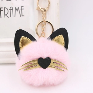 Detail view of pink plush cat keychain with golden whiskers and metal heart clip