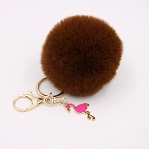 Detailed view of dark brown faux fur pom pom keychain with gold ring and pink flamingo charm