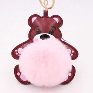 Détail du porte-clés ours en cuir avec pompon rose et anneau en métal doré brillant