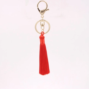 Détail d'un porte-clés à pompon rouge soyeux avec fermoir mousqueton doré élégant