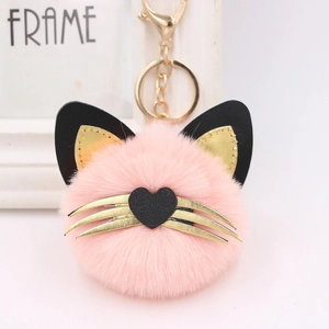 Detailed close-up of a pink plush cat keychain with golden whiskers and metal lobster clasp