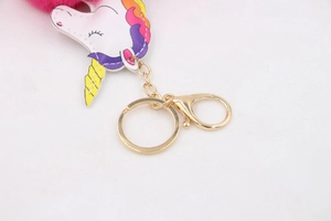 Détail d'un porte-clés licorne en fausse fourrure rose avec fermoir en métal doré poli