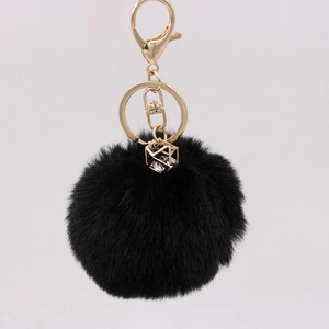 Detail of black faux rabbit fur keychain with gold lobster clasp and diamond charm