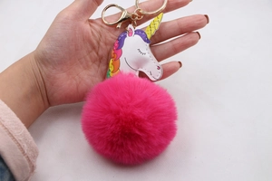 Vue détaillée porte-clés licorne avec un grand pompon en fausse fourrure fuchsia et clip